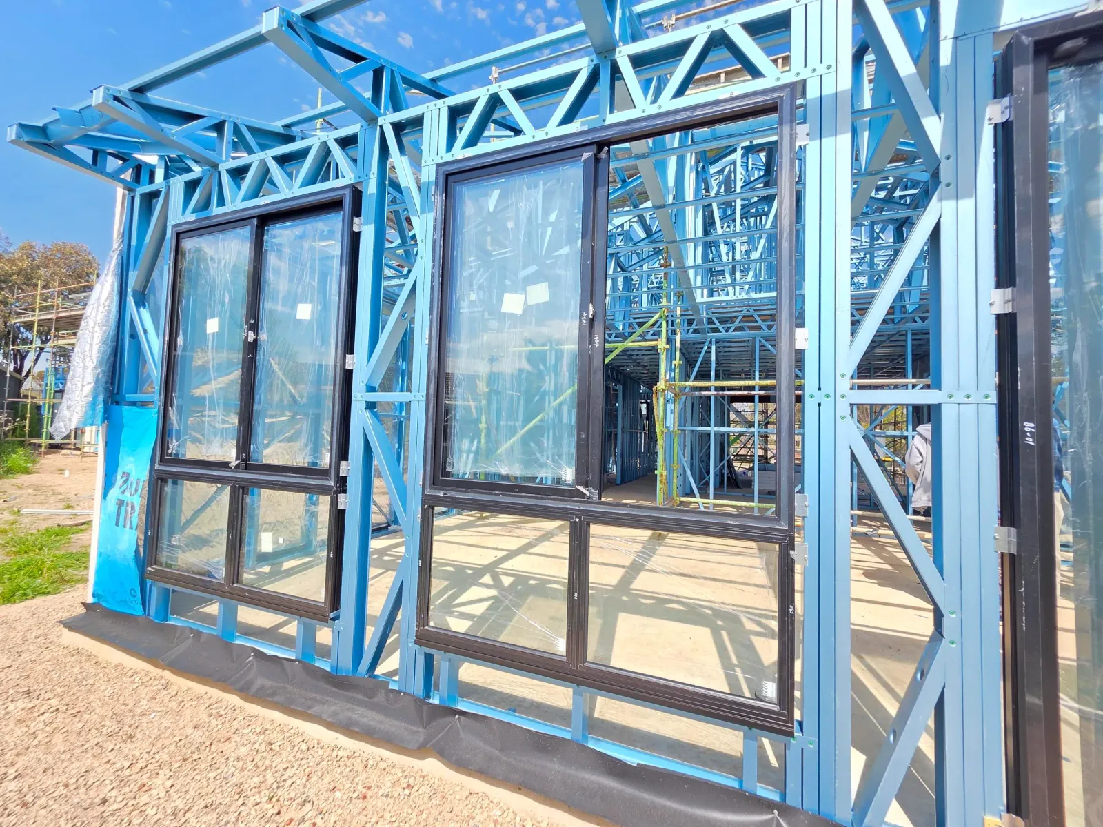 Black framed aluminium sliding windows installed into the steel frame of a Clearview home in Adelaide under construction